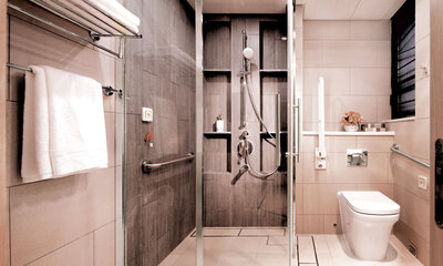 Bathrooms are designed with sliding doors, non-slip tiles, handrails, and curbless shower area.